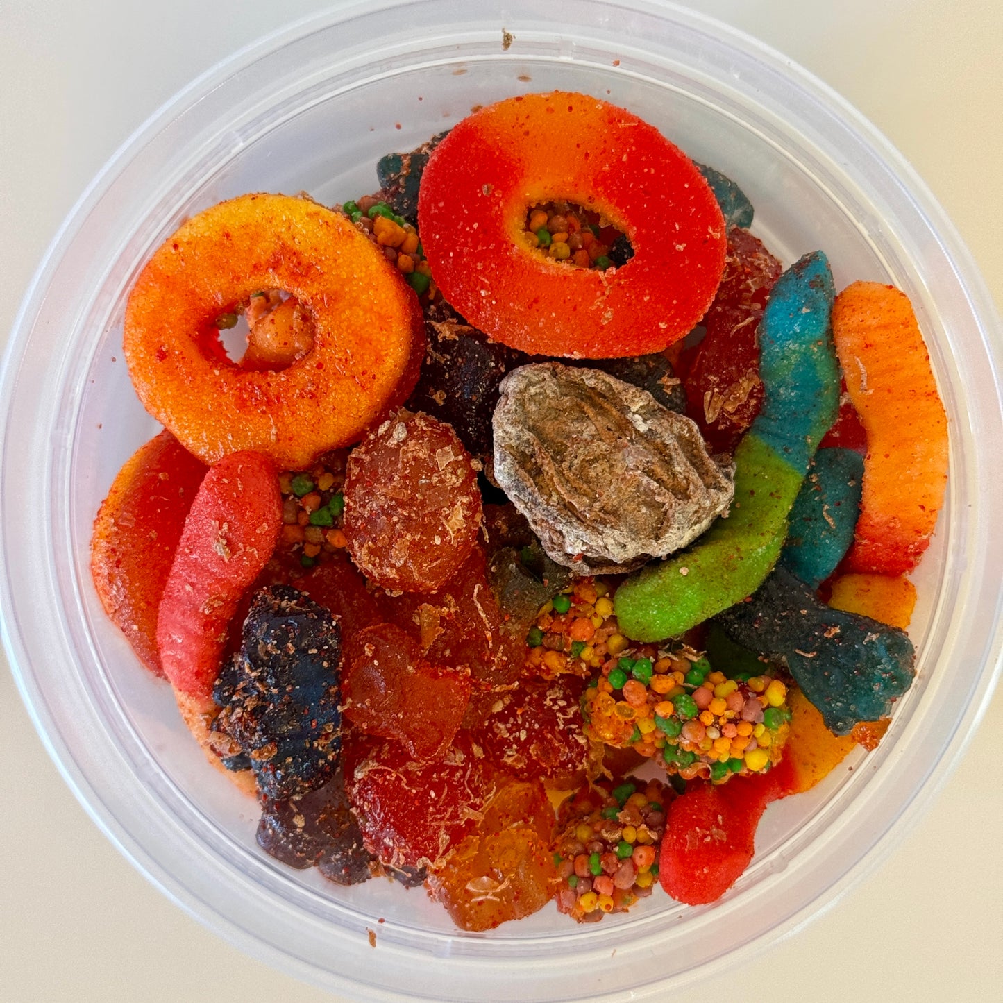 Aunty Kendra's Kamikaze Mix: Assorted gummy worms and rings covered in sweet and sour Li Hing Mui powder.