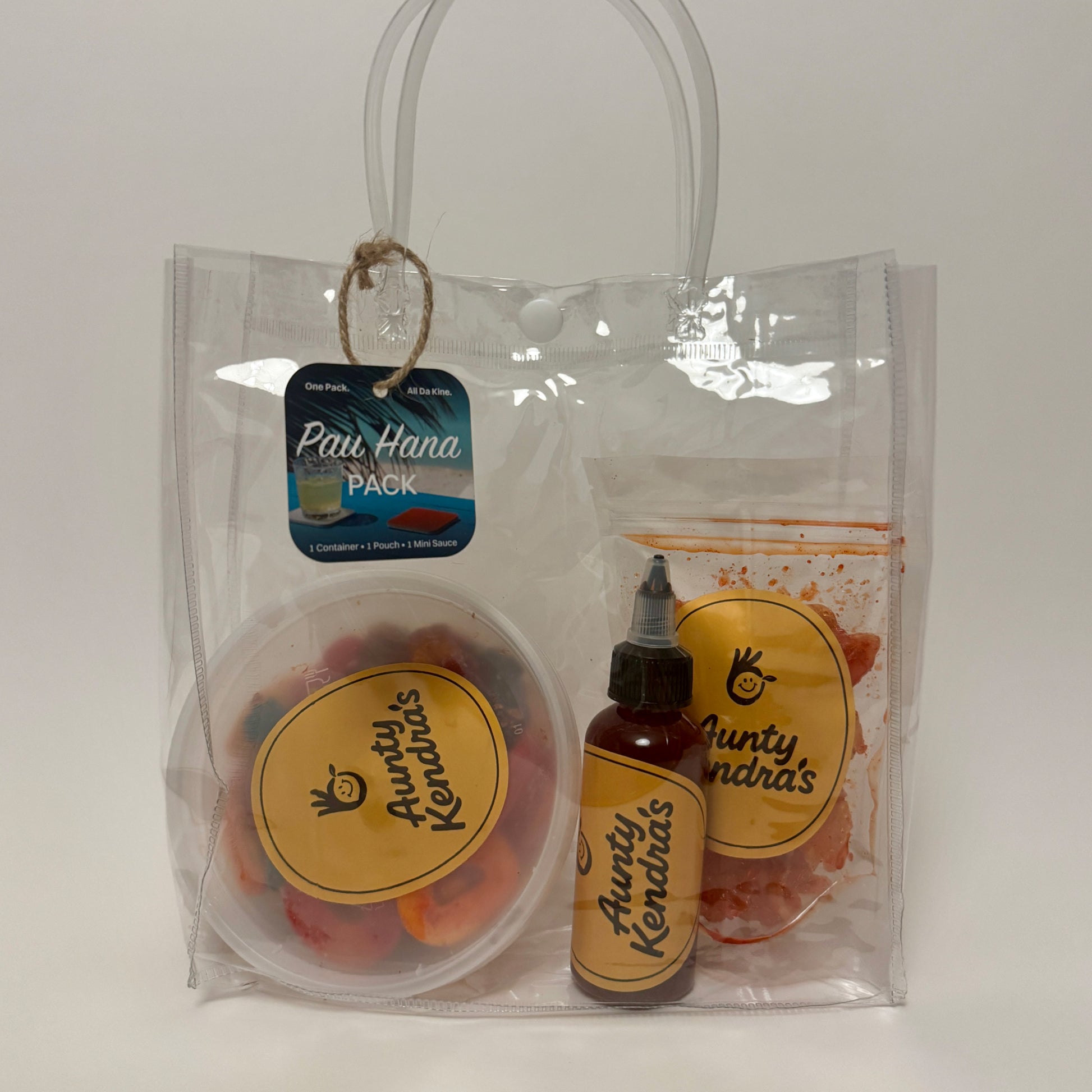 Aunty Kendra's Pau Hana Pack: A gift bundle featuring 2oz Li Hing Mui Sauce, a container of li hing gummies, and a dried fruit pouch in a clear reusable tote.